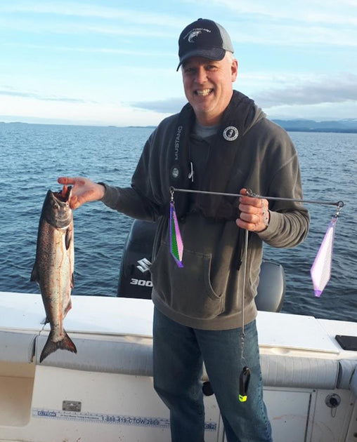 Glenn, the owner and designer of the CruciFish, holding the first prototype and the fish he just caught using it.